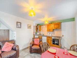 ein Wohnzimmer mit Tisch und Stühlen und eine Küche in der Unterkunft The Cottage - Uk43952 in Boosbeck