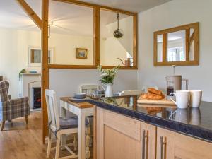 a kitchen with a counter and a table with bread at Cosy Cottage in Holker +8 photos