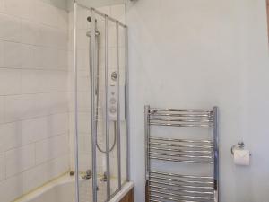a shower with a glass door in a bathroom at Sunflower Holiday Cottage in Alford