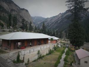 a building in the middle of a valley with mountains at Anakar resort in Kalām