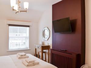 a bedroom with a bed and a flat screen tv at Middle Cottage in York