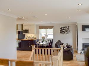 een keuken en een woonkamer met een tafel en stoelen bij Ingram Cottage in Bamburgh