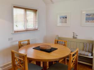 a dining room with a wooden table and chairs at Pottery Cottage in Broadway