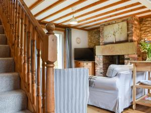 a living room with a staircase and a couch at Fox Cover Cottage in Great Edston