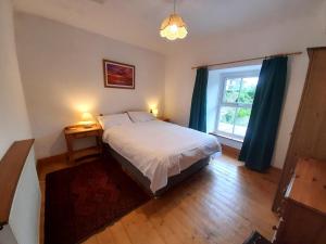 a bedroom with a large bed and a window at Uplands Newport, Pembrokeshire in Newport Pembrokeshire