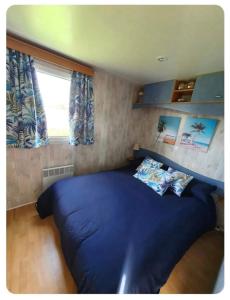 un grand lit bleu dans une petite pièce avec une fenêtre dans l'établissement La quinta olac acogedor bungalow independiente, à Pedreira 13 autres photos