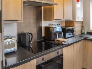 a kitchen with a stove and a microwave at Grosvenor Apartment in High Heaton