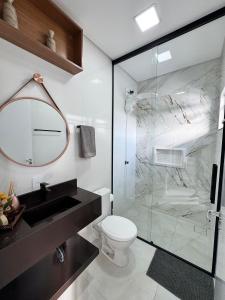 een badkamer met toilet en glazen douche bij Casa Nova - Moderna | 700m praia | 8 min parque in São Lídio