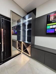 een kleedkamer met een televisie en een kast bij Casa Nova - Moderna | 700m praia | 8 min parque in São Lídio