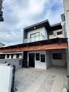 een groot wit huis met een grote patio bij Casa Nova - Moderna | 700m praia | 8 min parque in São Lídio