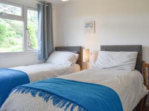 zwei Betten in einem Zimmer mit Fenster in der Unterkunft Chalet 6 - Uk12566 in Mount Hawke