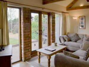 a living room with a couch and a table at Sunflower Holiday Cottage in Alford