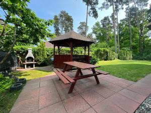 a picnic table with a gazebo in a park at Dom Gościnny Sówka in Pobierowo +61 photos