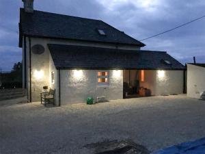 a white house with lights on the side of it at Cuillin View Apartment - Uk12529 in Arisaig