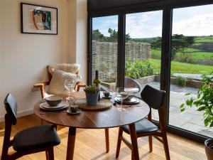 セント・ジャストにあるThe Hen House-Uk12928のテーブルと椅子と窓のあるダイニングルーム