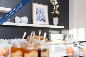 a counter with plates and bowls on a shelf at Hôtel Les Voiles in Toulon
