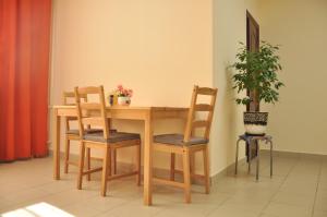 einem Holztisch mit vier Stühlen und einer Topfpflanze in der Unterkunft 4 Komnaty in Jaroslawl