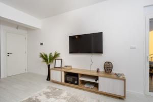 un soggiorno con una TV a schermo piatto su una parete di Alpha Mare a Bar