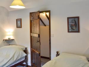 a bedroom with a bed and an open door at Oxlow End Cottage in Peak Forest +9 photos