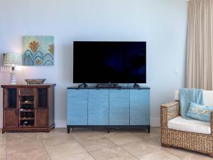 un salon avec une télévision sur une commode bleue dans l'établissement Caribe The Resort #D714, à Orange Beach