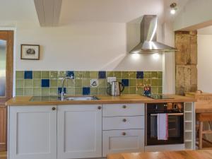 a kitchen with white cabinets and a sink at Winebeck Farm Studio in Addingham