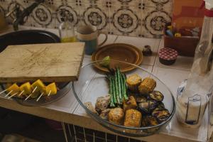 a counter top with a bowl of food and a plate of vegetables at Villa Clementina in Barcelos