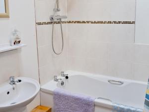 a bathroom with a bath tub and a sink at Ploughman's Cottage in Flamborough