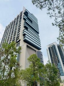 a tall building with trees in front of it at Wall Street Signature Suites-Mall of Islamabad Blue Area F-7 in Islamabad