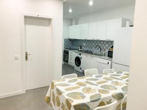 uma cozinha com mesa e cadeiras e uma cozinha com fogão em Casas Sao Luis em Faro