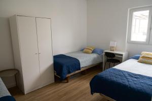 um quarto com duas camas e um armário em Casas Sao Luis em Faro