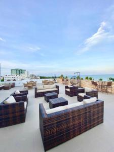 a patio with couches and tables and the ocean at Imperial Flat 111 Beira Mar Tambaú in João Pessoa