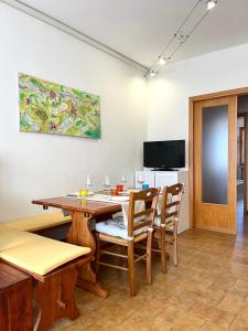 Un comedor con mesa y sillas y un televisor. en La Casa Del Mare, en Torre del Lago Puccini