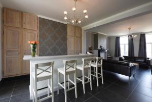 a kitchen and living room with a bar with stools at Rue du Canal in Alveringem
