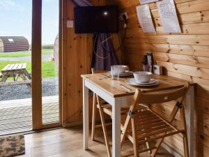 a table and chairs in a cabin with a television at Withy Bottom-Uk1393 in Corney