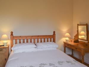 a bedroom with a bed with two lamps and a mirror at Shorley Lodge in Keswick