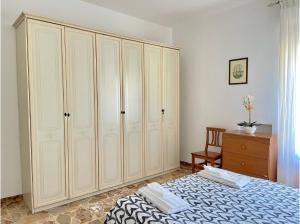 a bedroom with white cabinets and a bed and a dresser at Florentine Castle Apartment in Castelfiorentino