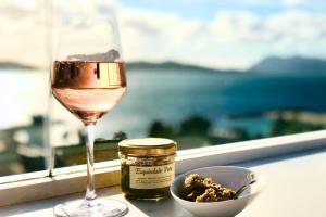a glass of wine and a bowl of food next to a window at Hôtel Les Voiles in Toulon