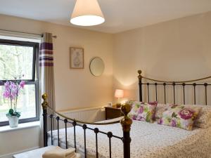 ein Schlafzimmer mit einem Bett und einem Fenster in der Unterkunft Park View Cottage in Old Glossop