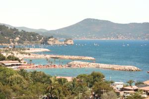 a beach with a bunch of people in the water at Hôtel Les Voiles in Toulon