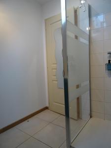 a bathroom with a door and a tiled floor at Relais Solognot in Sennely