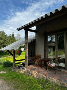 a porch of a house with a table and chairs at Eha Farmstay in Rõuge