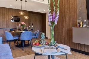 a table with a bowl of fruit and a vase of flowers at Golden Hour Apartments- Loft H 214 in Świnoujście +15 photos