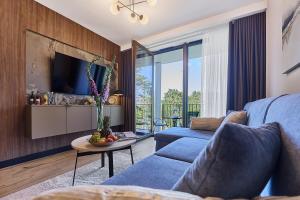 a living room with a blue couch and a table at Golden Hour Apartments- Loft H 214 in Świnoujście