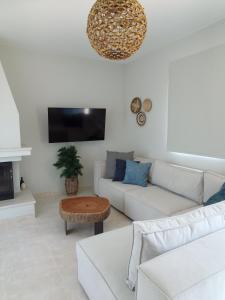 a living room with a white couch and a table at Vasilopoulos Residences - Villa Kalliste in Argostoli