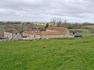 a green field with a group of buildings in the background at The Loft - 26477 in North Willingham +2 photos