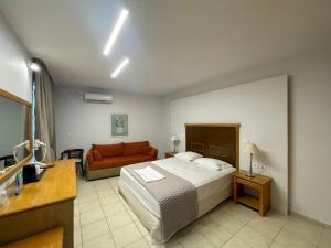 a hotel room with a bed and a couch at Danae Hotel in Egina