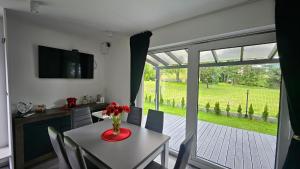 a dining room with a table with a vase of flowers on it at Spokojny zakątek in Ustroń