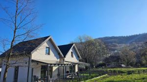a white house with a mountain in the background at Spokojny zakątek in Ustroń