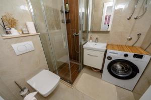 a bathroom with a washing machine and a shower at Alpha Neo in Bar +16 photos