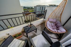 a balcony with a hammock chair and a table at Alpha Neo in Bar